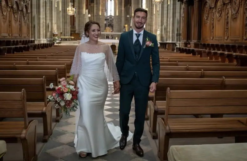 Clémence et son marié remontent l'allée d'une cathédrale.