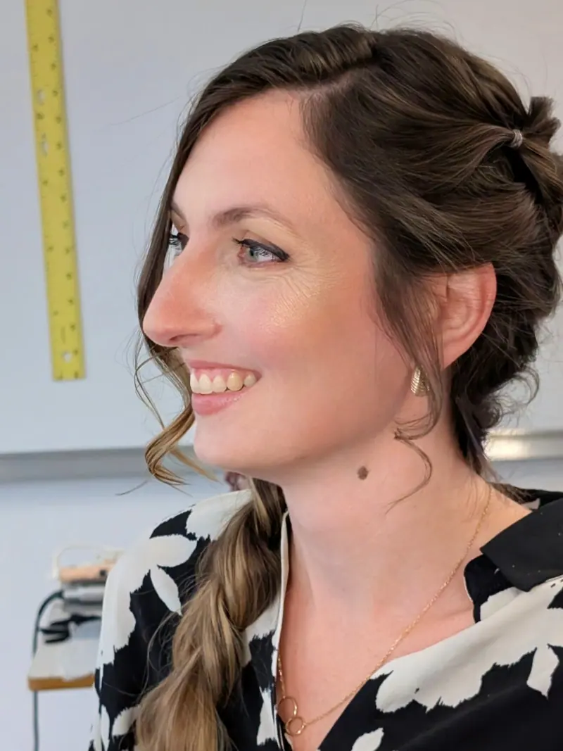 Maquillage naturel et coiffure tressée sur le côté, vue de trois quarts.